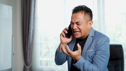 Asian Businessman Talking on Smartphone in Modern Office