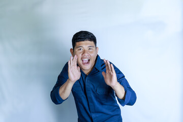 A young man felt happy, shouting loudly with his hand beside his mouth
