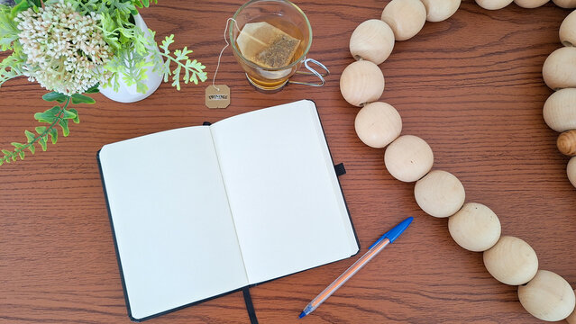 Caderno com papel em branco, caneta e ch&aacute;