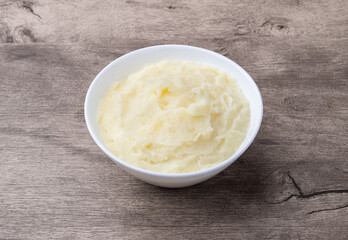 Mashed potatoes in a bowl over wooden table