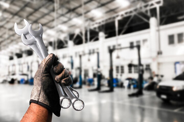 Mechanic holding wrenches in automotive workshop , Slim Open-end Wrench in  mechanic hand , Automotive repair concept
