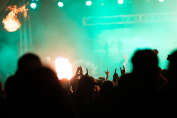Crowd at concert and colorful stage lights.