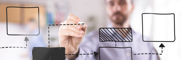 Focused businessman organizing flowchart elements, building structured framework for efficient...