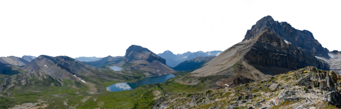 Panorama of Rocky Mountain scene with small lake large mountain distant blue hills and transparent sky. Banff Canada