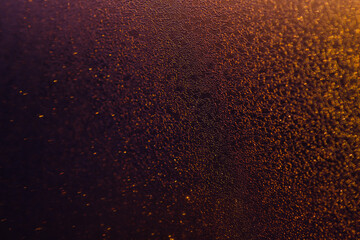 Blurred bokeh light sparkle on golden black background