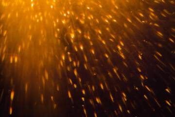 Blurred bokeh light sparkle on golden black background