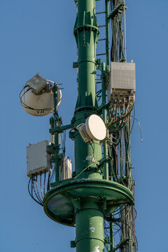 Communication tower stands tall against a bright blue sky, showcasing intricate technology and design in a serene landscape