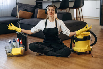 Keep calm, meditating. Female professional cleaning service worker is domestic room