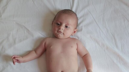 Baby massage on white sheets, relaxing touch for infant wellbeing