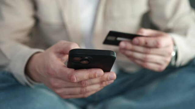 A man uses a bank card for online shopping.
A credit card in a man's hands.
A businessman transfers money from card to card.
A bank account.
A bank transfer of money