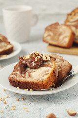 A piece of marble biscuit with chocolate cream and nuts