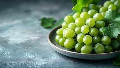 Green grapes on a plate with leaves