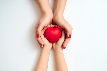 Hands gently uplifting soft red heart representing empathy nurturing and youth advocacy on pristine backdrop encouraging inclusive mindset philanthropic gestures and social harmony.