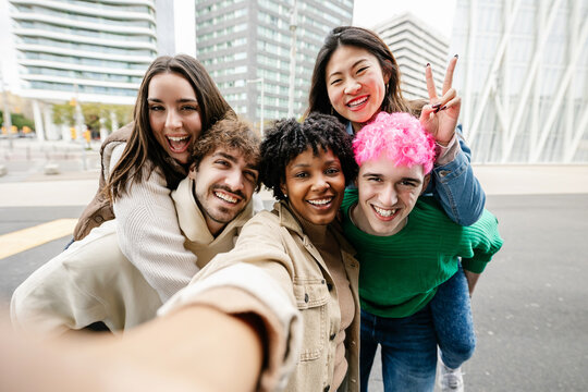 Young group of diverse people taking selfie portrait together at city street. Pretty African American woman standing together with college student friends outdoors. Youth community and travel concept - Powered by Adobe