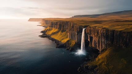 Seaside cliffs landscapes idea. Stunning waterfall cascading down cliffs into a serene ocean view under a dramatic sky.
