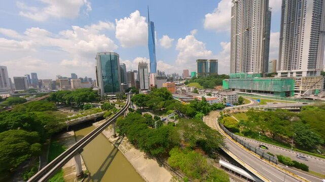 Cinematic FPV drone flight over LRT train tracks with Kuala Lumpur city skyline