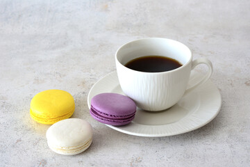 Coffee cup with saucer and Colorful Macarons on a Plate