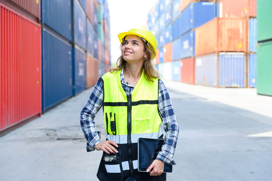 Engineer women wear yellow helmets and reflection shirts working on tablet computers to check inventory details of containers box. Inspector or Safety Supervisor in Container Terminal. - Powered by Adobe