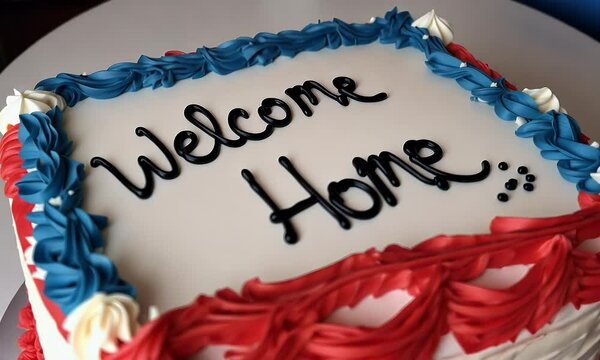 Welcome Home Cake with Red White and Blue Frosting Featuring a Text Message on Top of Cake with Swirled Frosting Decorations on a White Surface. Featuring a Colorful Celebration Cake. Featuring