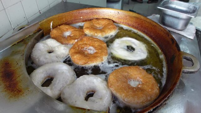 Deep-frying traditional 'bambalouni' snacks in bakery in small village of Sidi bou Said in Tunisia
