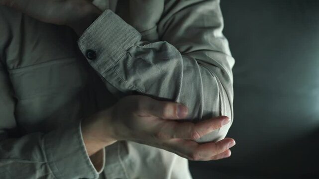 Hand injury.
Elbow pain.
Hand massage during injury.
Person with sore elbow.
Broken arm in guy