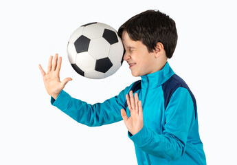 Little boy with blue track-suit playing sport being hit by a soccer ball with force in the face when he misses a catch or as an unexpected accident to a spectator against white background © cunaplus