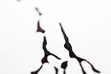 Extreme close up of black acrylic paint texture on paper. Selective focus.