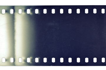 Dusty and grungy 35mm film texture or surface. Perforated scratched camera film isolated on white...
