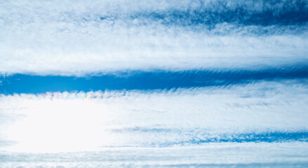 Obraz premium Dramatic blue sky background. Picturesque colorful clouds lit by sunlight. Vast sky landscape panoramic scene