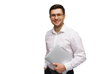 Young man in white shirt smiling confidently while holding a laptop in a bright setting