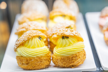 A beautifully designed restaurant communal space features sleek wooden benches positioned near a floor-to-ceiling glass facade, allowing natural light to flood the area. The warm tones of the wood