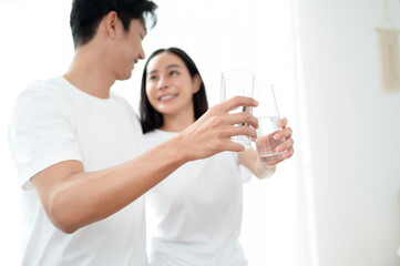 Couple Enjoying Refreshing Drinks Together in a Bright, Airy Room During a Cozy Moment