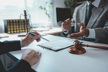 Legal professionals reviewing contract documents, gavel and justice scale marking professional...