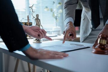 Legal professionals examining contract provisions, law office setting featuring gavel and Themis...