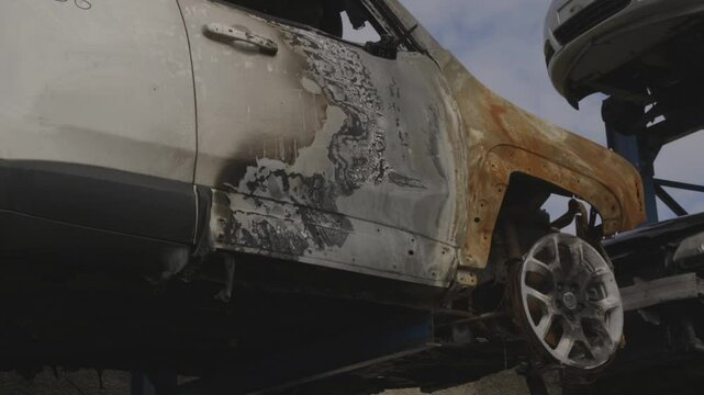 auto bruciata dopo un litigio, depositata in uno sfascia carrozze.