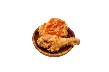 Fried chicken with sauce on top and served on a wooden plate, isolated on white background
