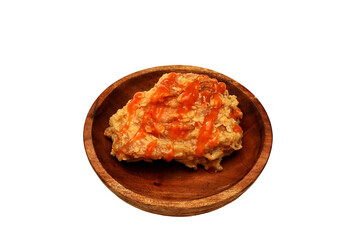 Fried chicken with sauce on top and served on a wooden plate, isolated on white background