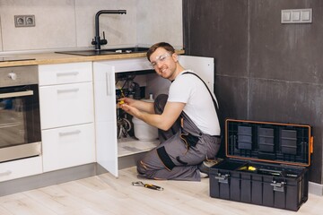 Plumber Installing Water Filter System Under Kitchen Sink