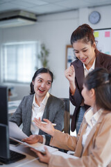 Excited businesswomen celebrating successful project, discussing strategy in office meeting, demonstrating teamwork and achievement