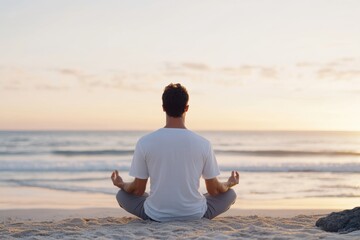 Fototapeta premium Mindfulness: Man practices yoga on a sandy beach at sunset, embracing peace and tranquility