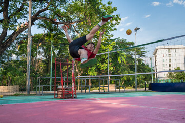 Male Asian Sepak Takraw player kicking Sepaktakraw ratten ball in court