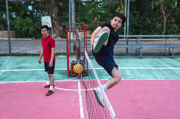 Obraz premium Asian male Sepaktakraw players playing traditional Sepak Takraw sports in outdoor court