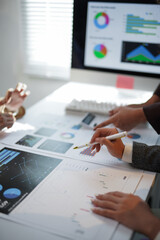 Business team analyzing financial data and investment strategy planning during a meeting in the...