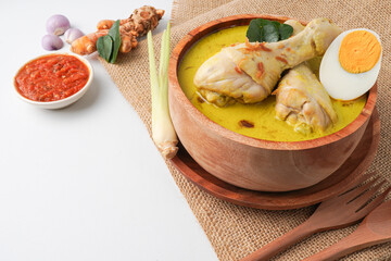 Lontong opor ayam is an Indonesian traditional dish usually served during eid Mubarak, Eid al Fitr holiday celebration with Ketupat Lebaran or rice cake dumpling and sambal chili sauce.