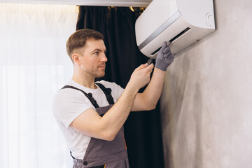Plumber Repairing Air Conditioner Using Screwdriver