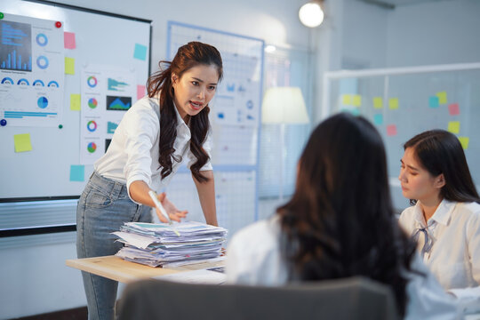 Asian businesswomen getting a scolding from their manager for poor performance during an office meeting