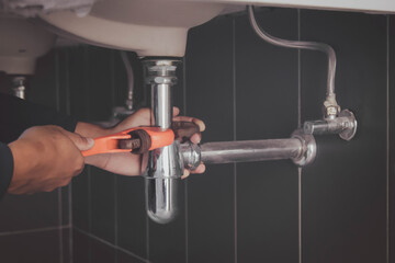 plumber at work in a bathroom, plumbing repair service , fix water plumbing leaks, replace the...