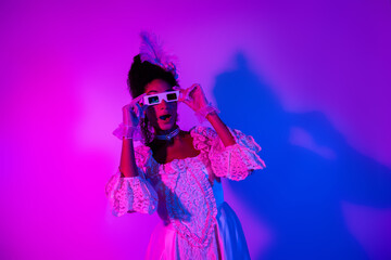 Elegant woman in vintage lace dress posing with 3D glasses against vibrant neon pink and purple lights