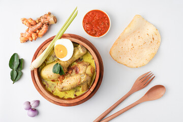 Lontong opor ayam is an Indonesian traditional dish usually served during eid Mubarak, Eid al Fitr holiday celebration with Ketupat Lebaran or rice cake dumpling and sambal chili sauce.