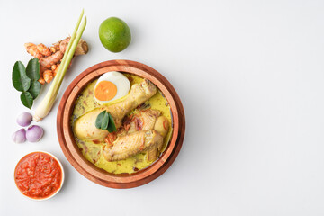 Lontong opor ayam is an Indonesian traditional dish usually served during eid Mubarak, Eid al Fitr holiday celebration with Ketupat Lebaran or rice cake dumpling and sambal chili sauce.